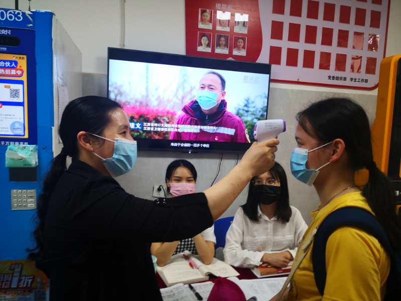 陈晓凡老师领志愿者在宿舍楼里为进出楼栋同学检测体温